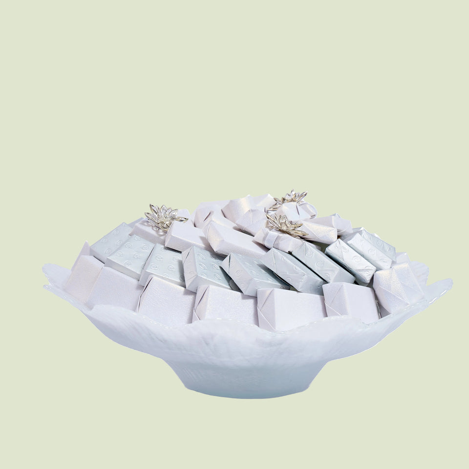 White Murano glass wavy dish side view with silver wrapped chocolates and star decorations
