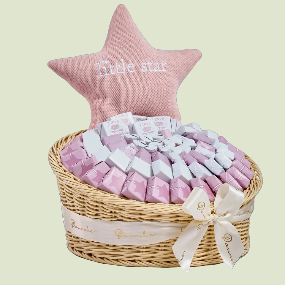 Baby girl chocolate arrangement with pink dragées in wicker basket and pink star balloon