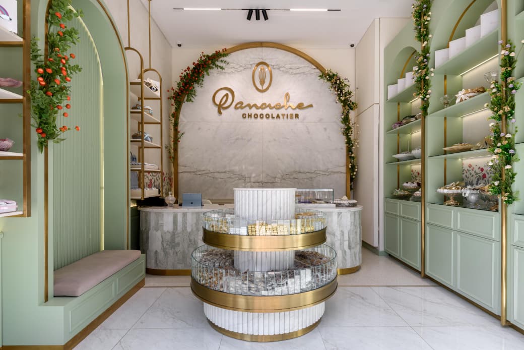Interior of the Panache boutique, with green cabinetry and a round chocolate display.